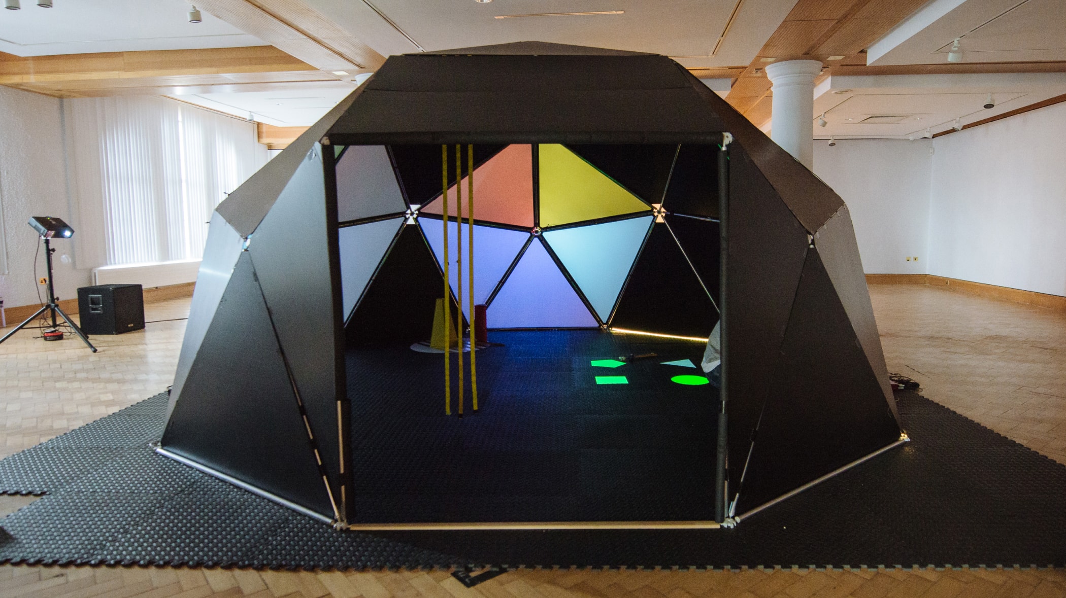 A black geometric dome with colours and instruments inside