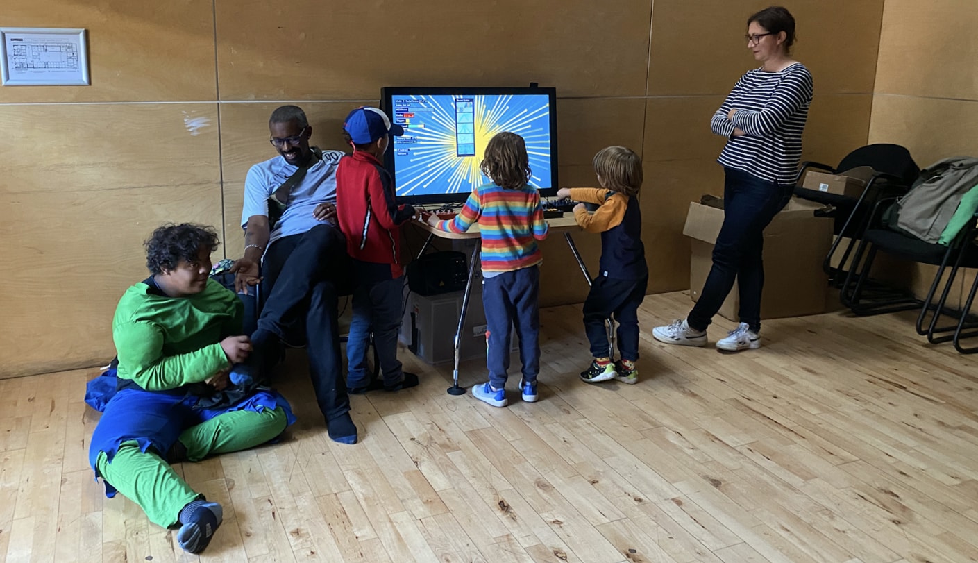A group of kids and adults play games on a screen