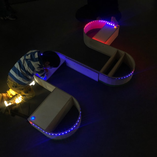 A child plays with a series of LED lights showing a sine wave